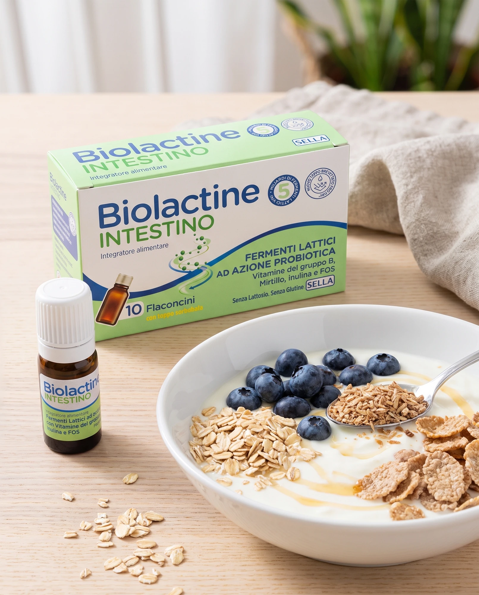 Pack and vial of Biolactine Intestino beside a bowl of yoghurt with blueberries and cereal