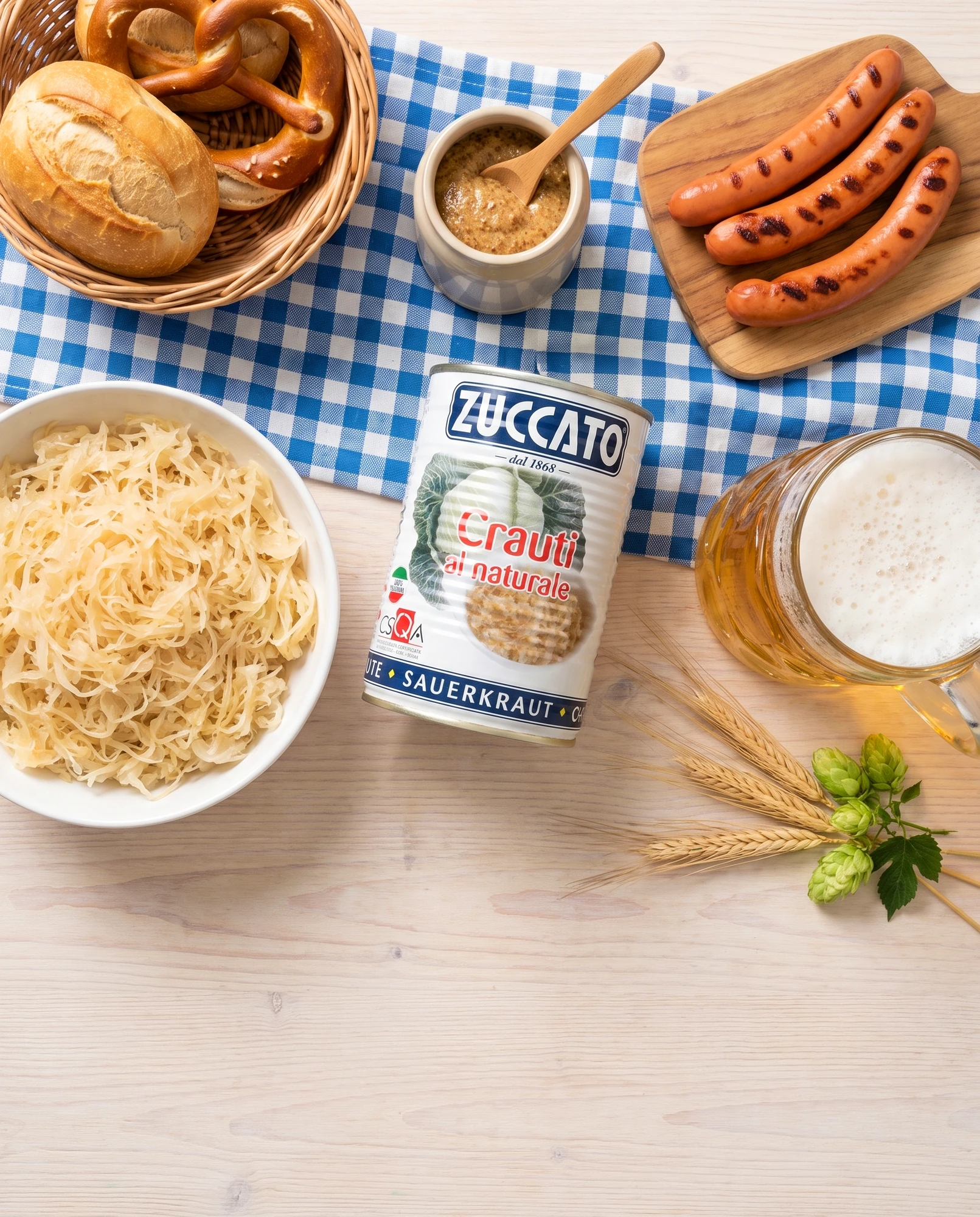 Tin of Zuccato Crauti al naturale with frankfurters, a pretzel, mustard and a beer mug on a checked tablecloth