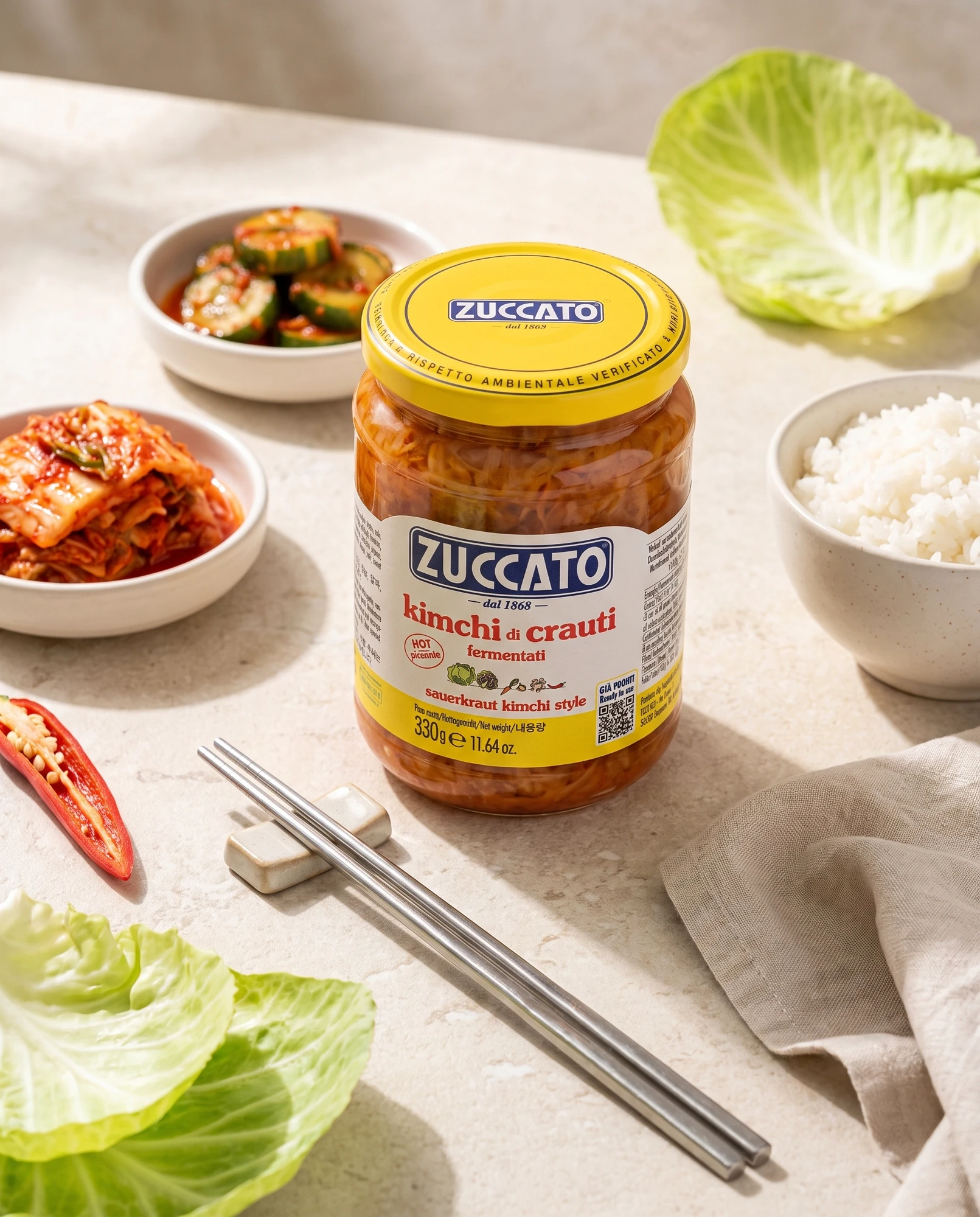 Jar of Zuccato Kimchi di crauti with rice, cucumbers, cabbage leaves, chilli and chopsticks