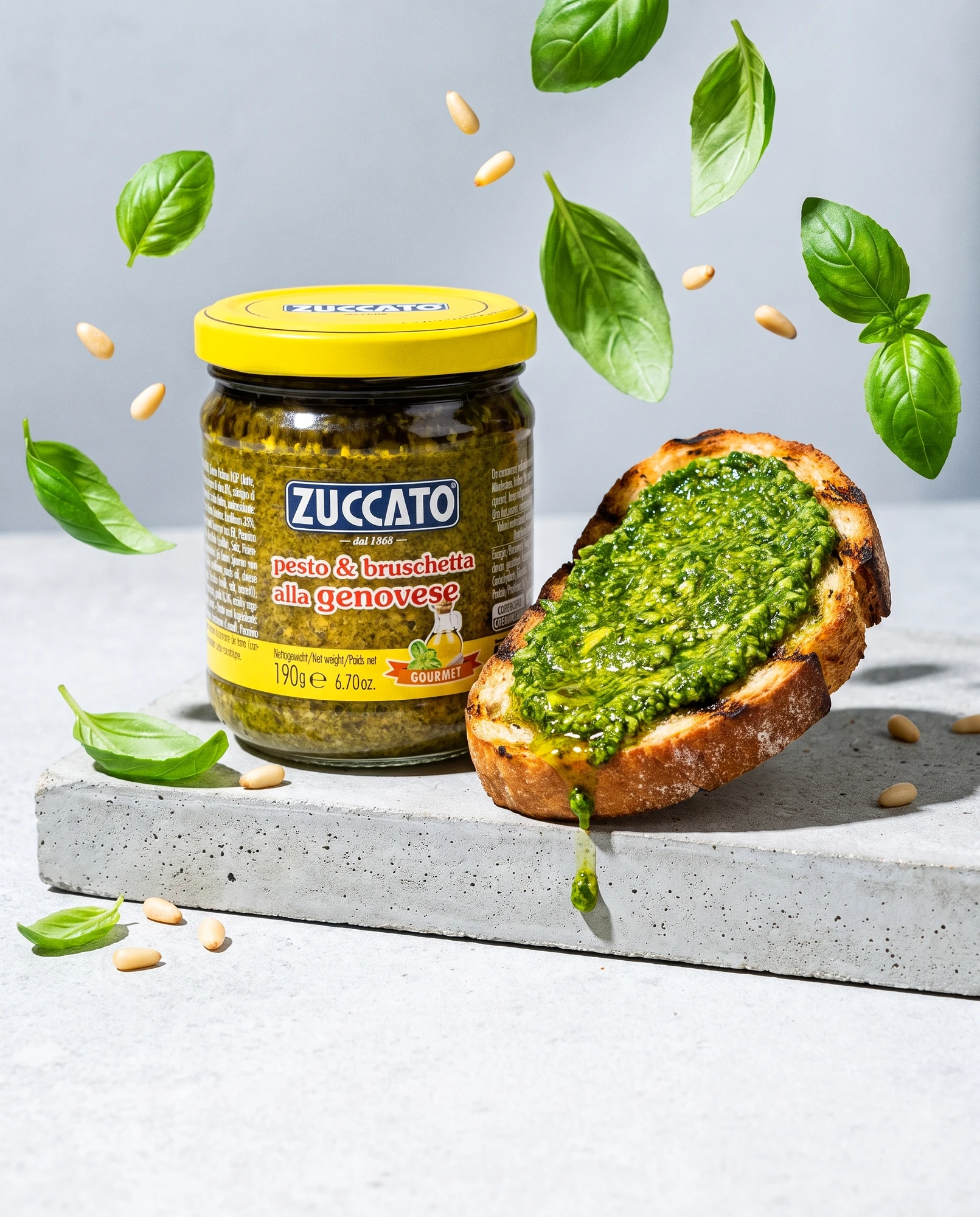 Jar of Zuccato Pesto alla genovese beside bruschetta with pesto, basil and pine nuts